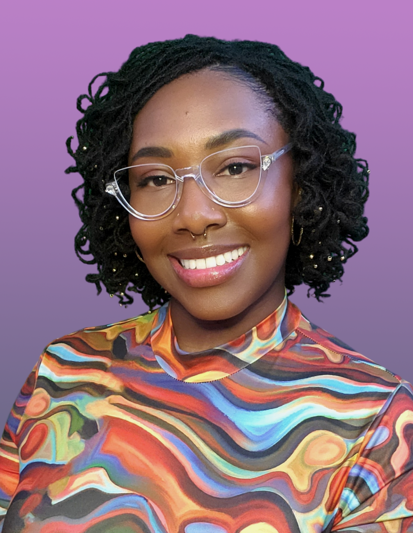 Jasmine Taylor smiling in a multi-colored blouse and clear glasses
